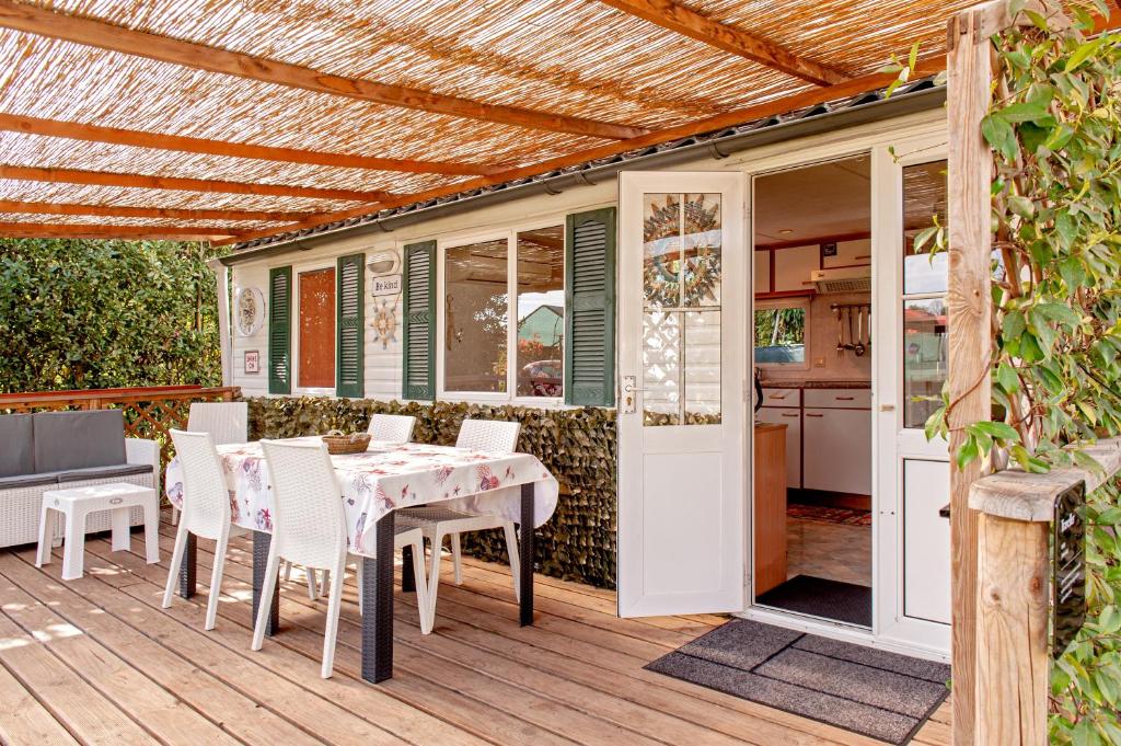 a patio with a table and chairs on a deck at Oasis on the river in Marina di Pisa