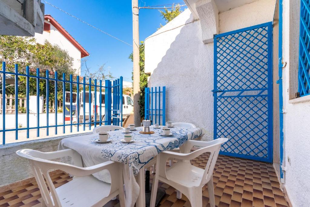 a table and chairs on a balcony with blue gates at Villetta Lido Canne in Torre Lapillo