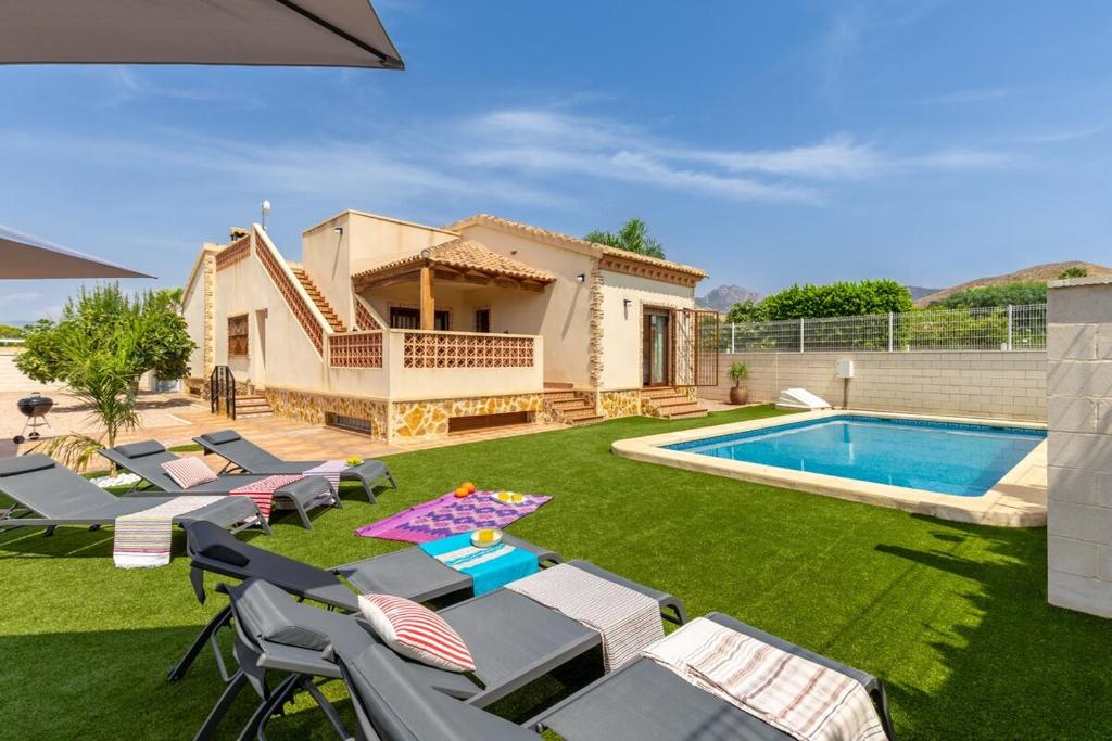 a backyard with a pool and chairs and a house at Mountain Beautiful by Fidalsa in Busot