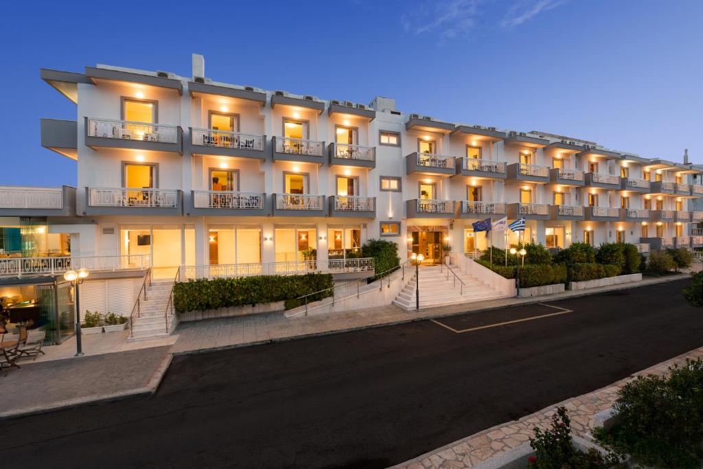 duży biały budynek z włączonymi światłami w obiekcie Akrata Beach Hotel w mieście Akrata
