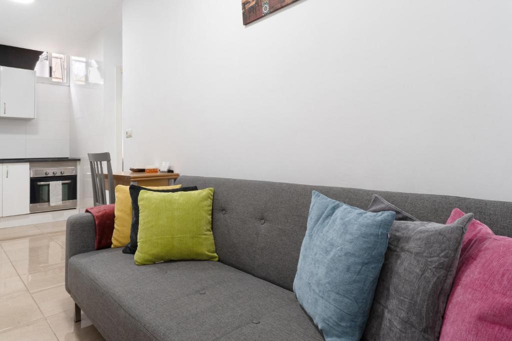 a gray couch with colorful pillows in a living room at Un descanso 1 in San Fernando