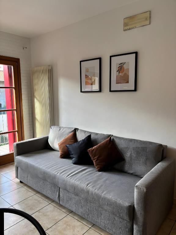 a gray couch with pillows on it in a living room at La Masera sul Torrente By Immobilux in Mori