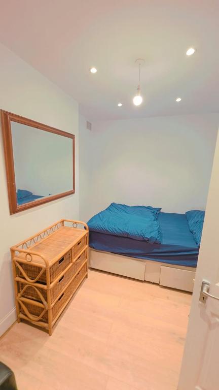 a bedroom with a bed with blue sheets and a mirror at Pyramid Homes in Slough