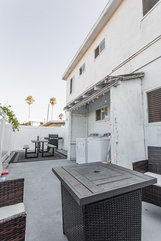 a patio with a table and a white building at 2bd Suite Steps To Beach! - Private Patio & Grill! in Oceanside