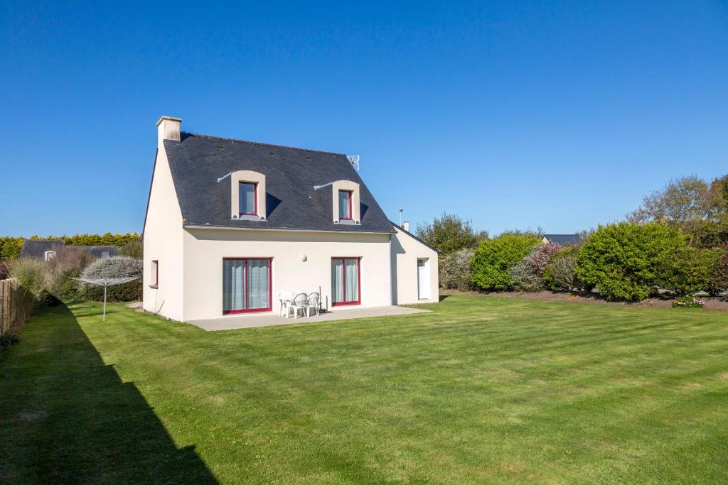 a white house with a yard with green grass at La Pause Bigoudène in Penmarch