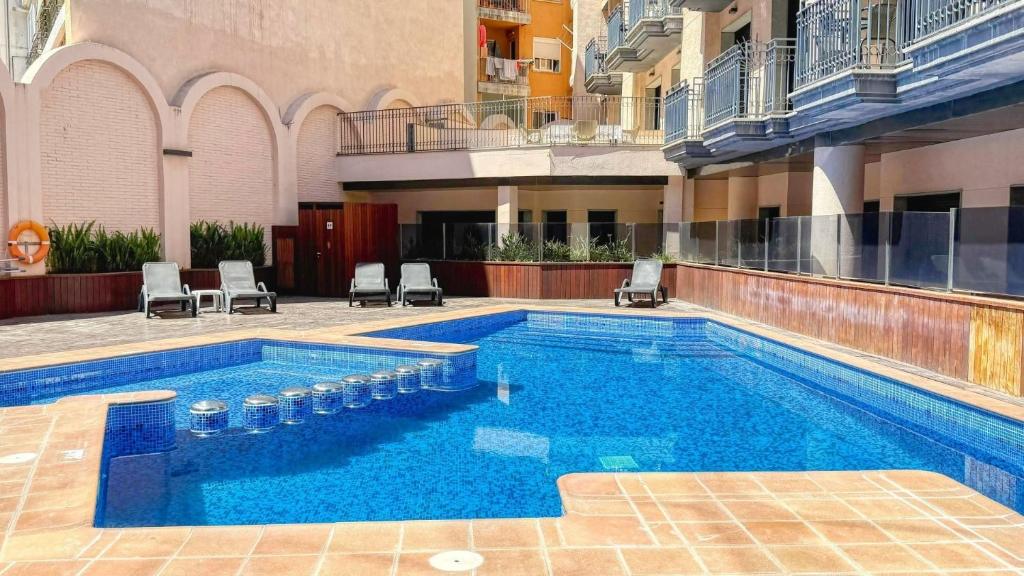 a swimming pool in the middle of a building at Costacabana - Apartment Dali in Lloret de Mar