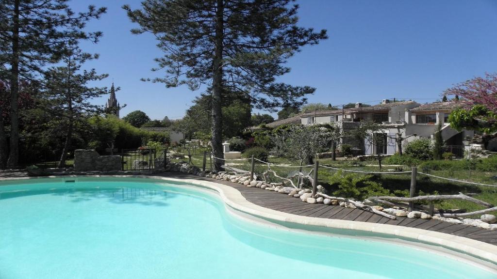 a large swimming pool in a yard with a house at L'arbre Du Magnan - Gîte En Ardèche in Chandolas