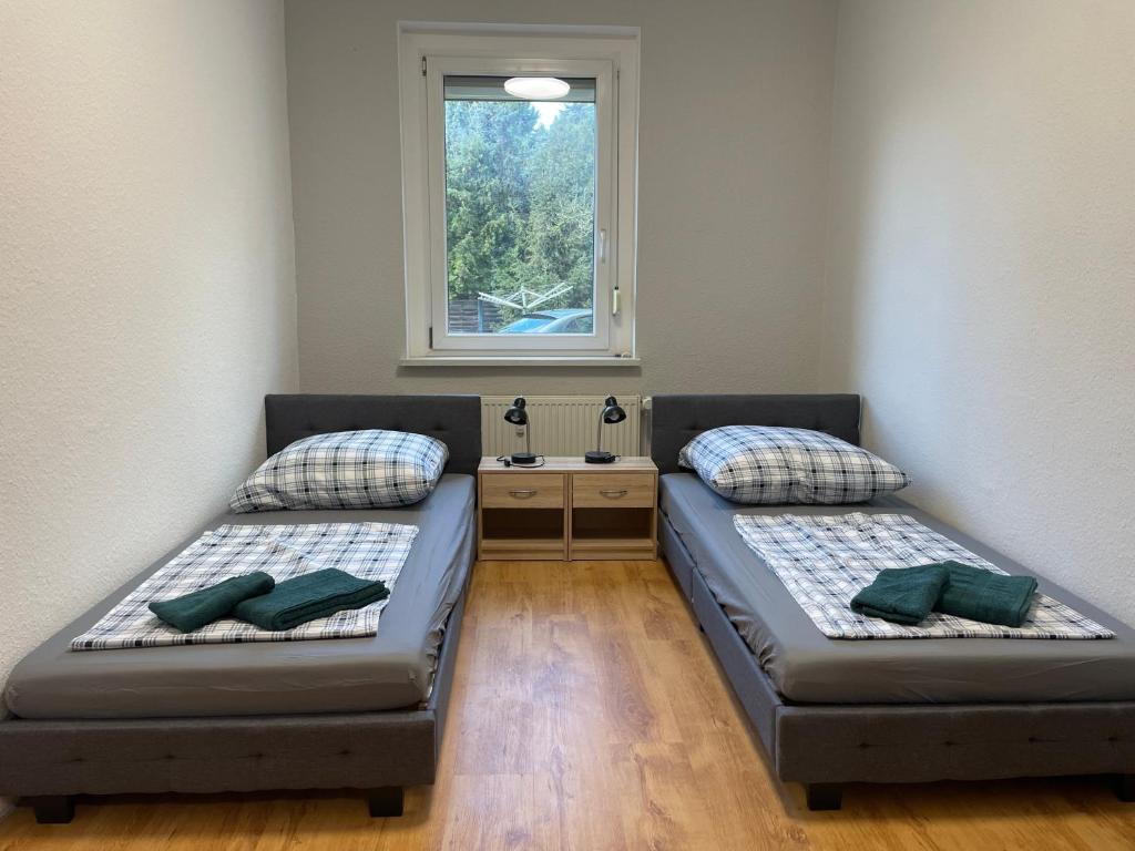 two beds in a room with a window at Das grüne Haus in Finsterwalde