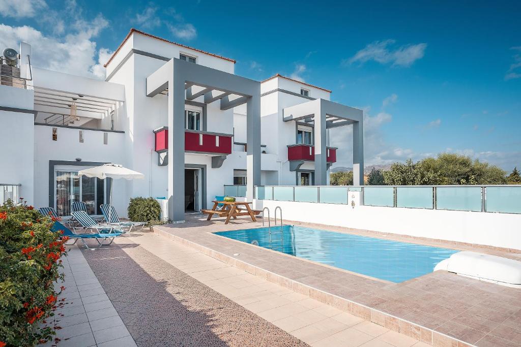a villa with a swimming pool and a house at Blue Pearl in Lachania