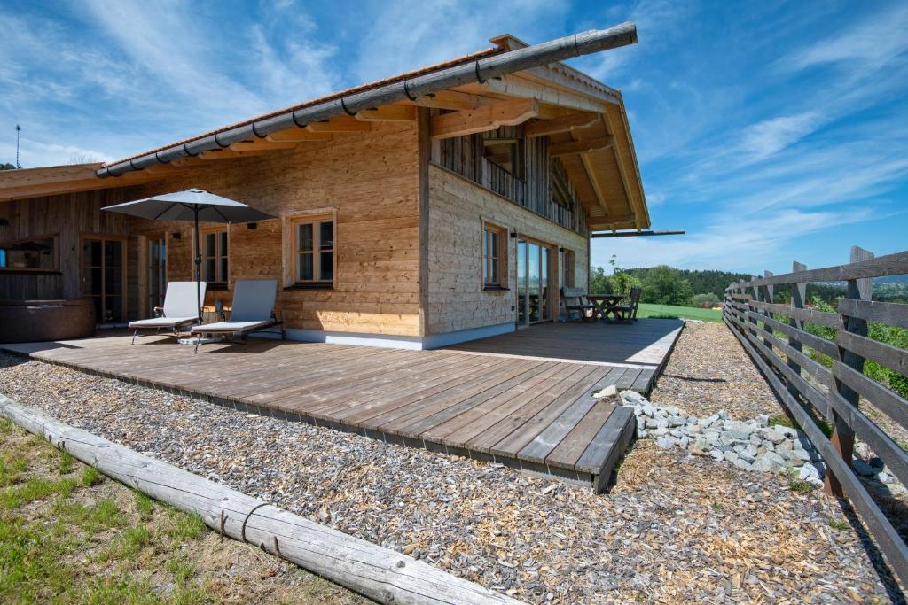 a house with a deck and an umbrella at Bergchalet 3 in Freyung