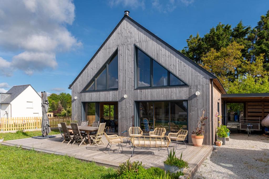 a barn style house with glass windows and a patio at Gite Familiale ty laouen in Sarzeau