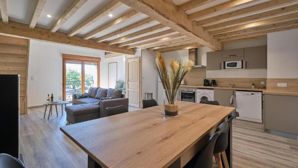 a kitchen and living room with a wooden table at Maison - Chez Louisette in Espezel