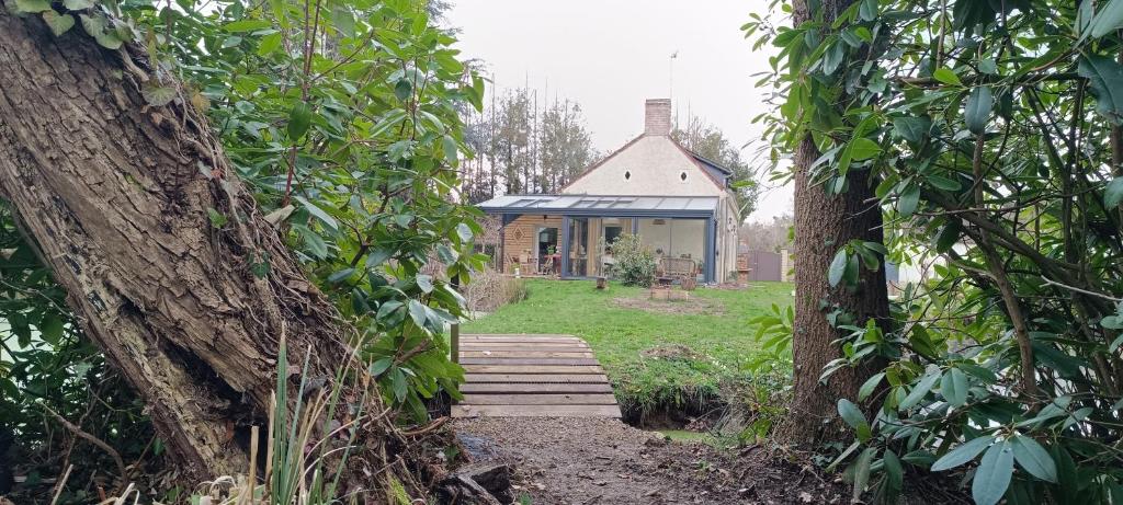 a house in the middle of a garden with trees at Chambres D'hôtes Les Préaux - in Cérans-Foulletourte