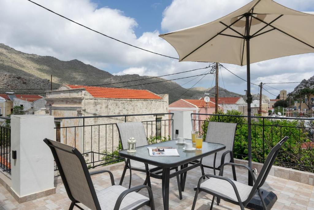 a patio with a table and chairs and an umbrella at Thea home Symi in Symi