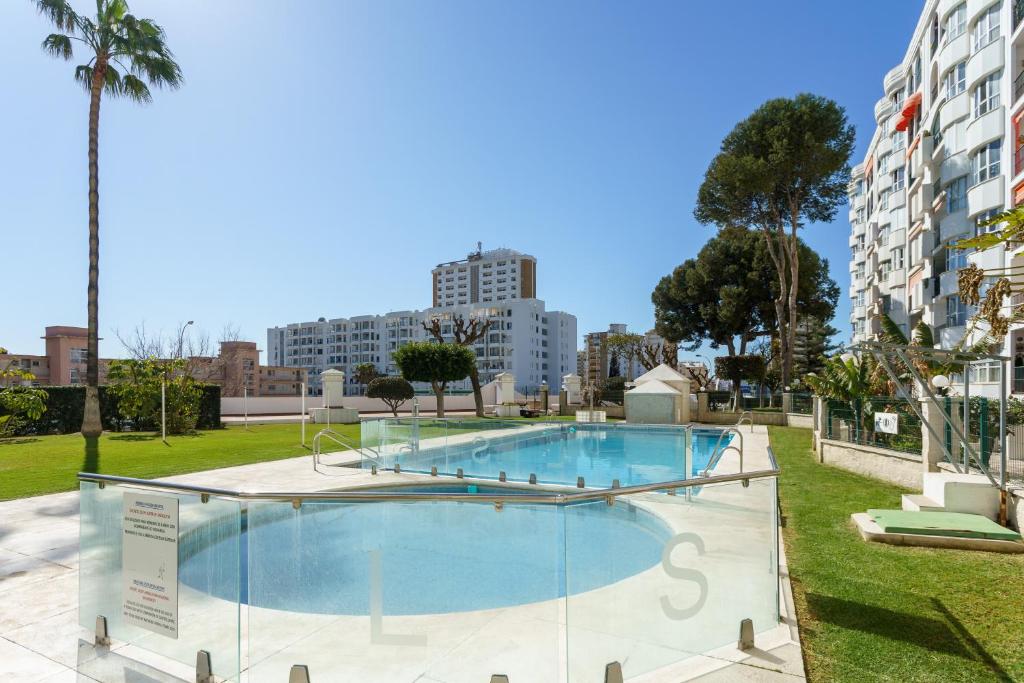 a swimming pool in a park with buildings in the background at Apartamento Lance del Sol in Fuengirola