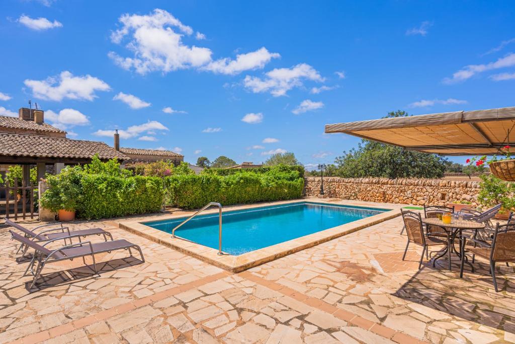 a swimming pool in a patio with a table and chairs at Son Galileu in Llucmajor