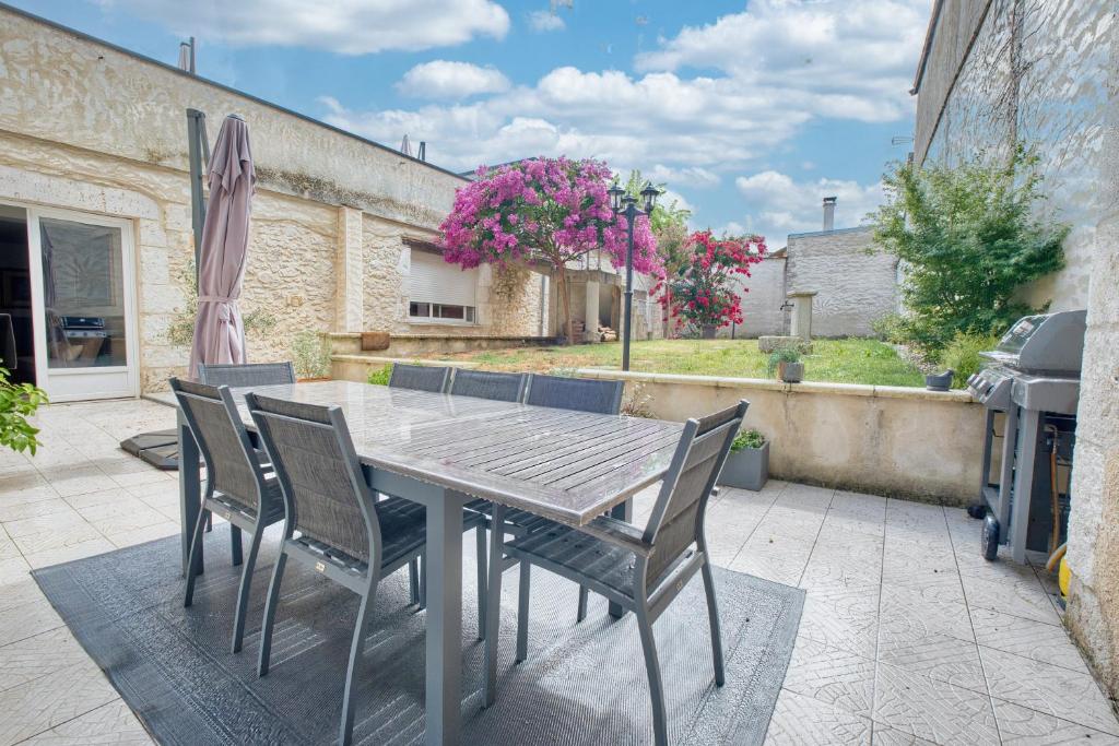 a wooden table and chairs on a patio at L'envie Eymet in Eymet