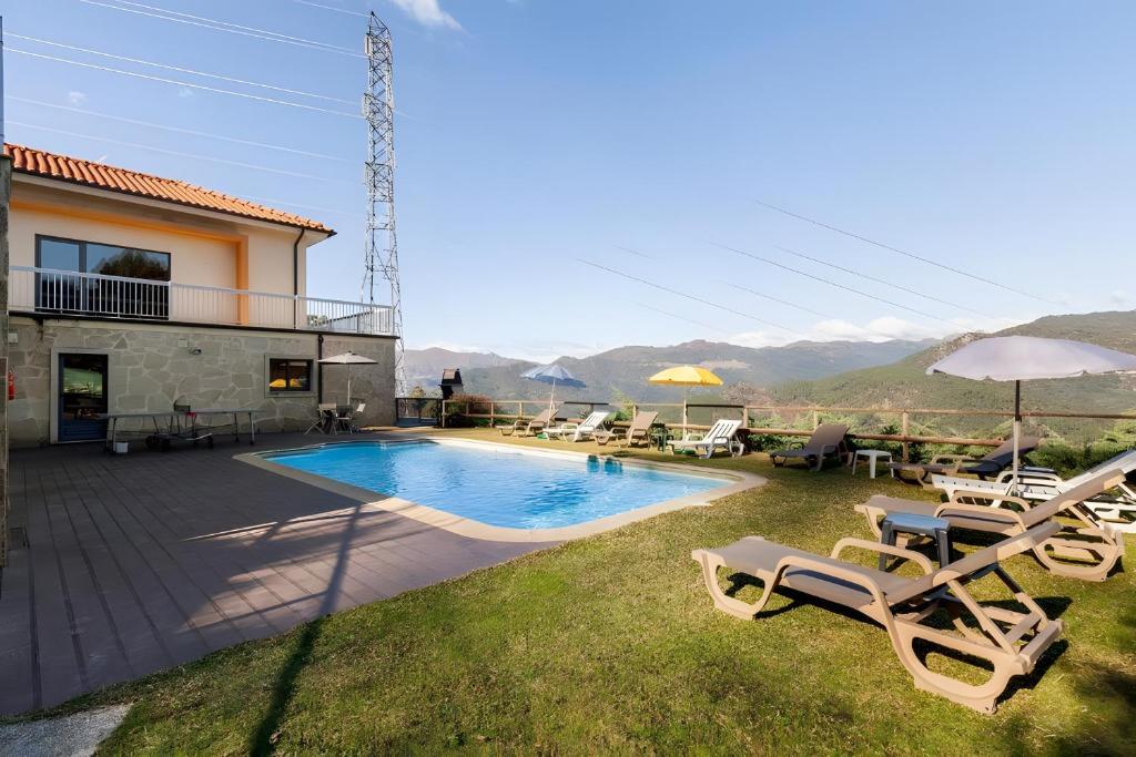 a villa with a swimming pool and chairs and a house at Casa de Balinhas - Gerês in Ventosa