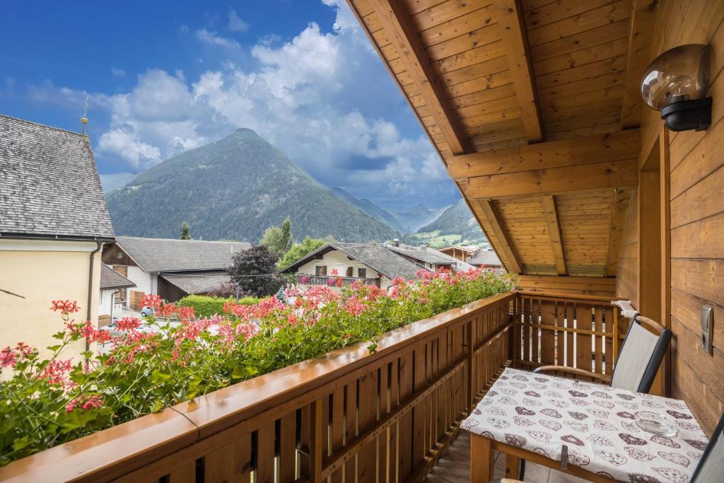 a wooden balcony with a table and flowers at Apartment Arnika - Mesnerhof in Sand in Taufers