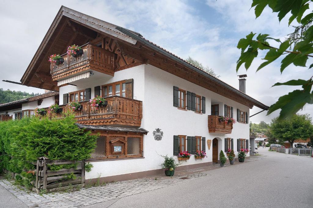 a building with wooden balconies and flowers on it at Ferienhaus Werdenfels in Mittenwald