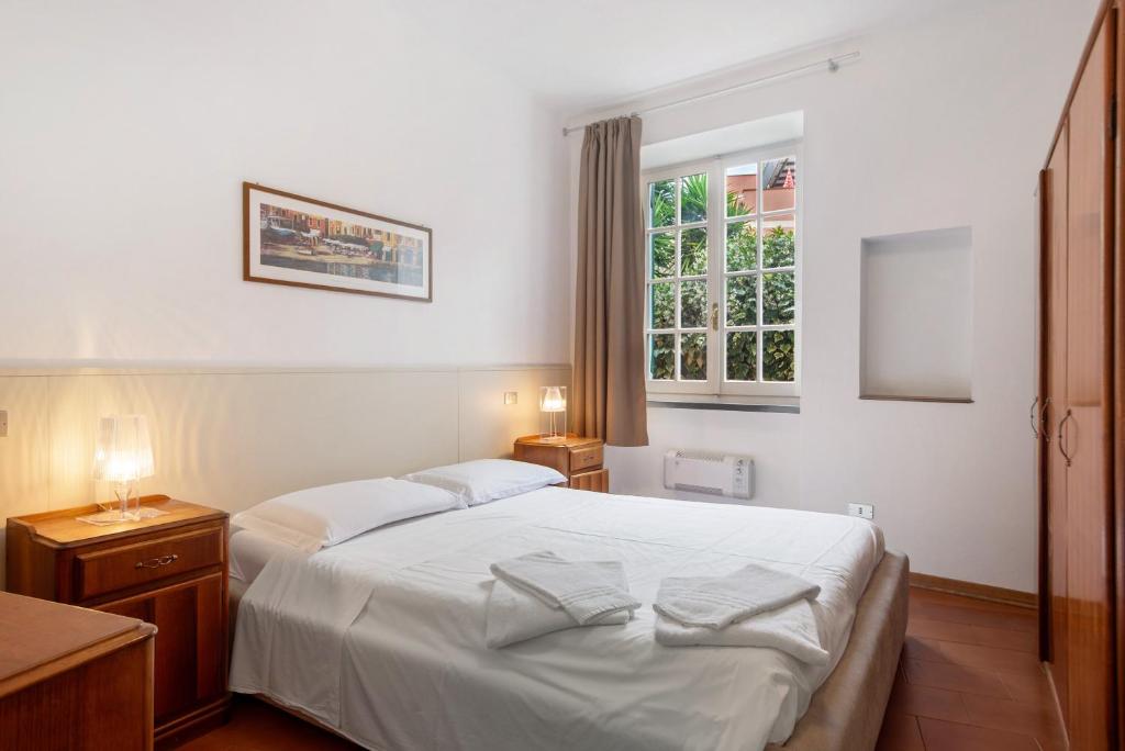 a bedroom with a white bed and a window at Via Colombo 12 - Trilocale in Bonassola