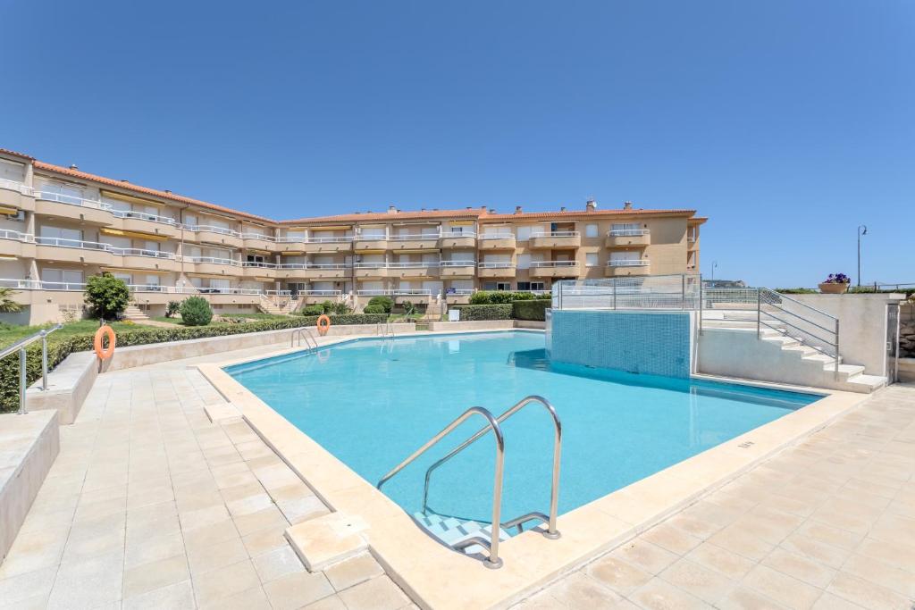 a swimming pool in front of a apartment building at Sunrise Medes in Torroella de Montgrí