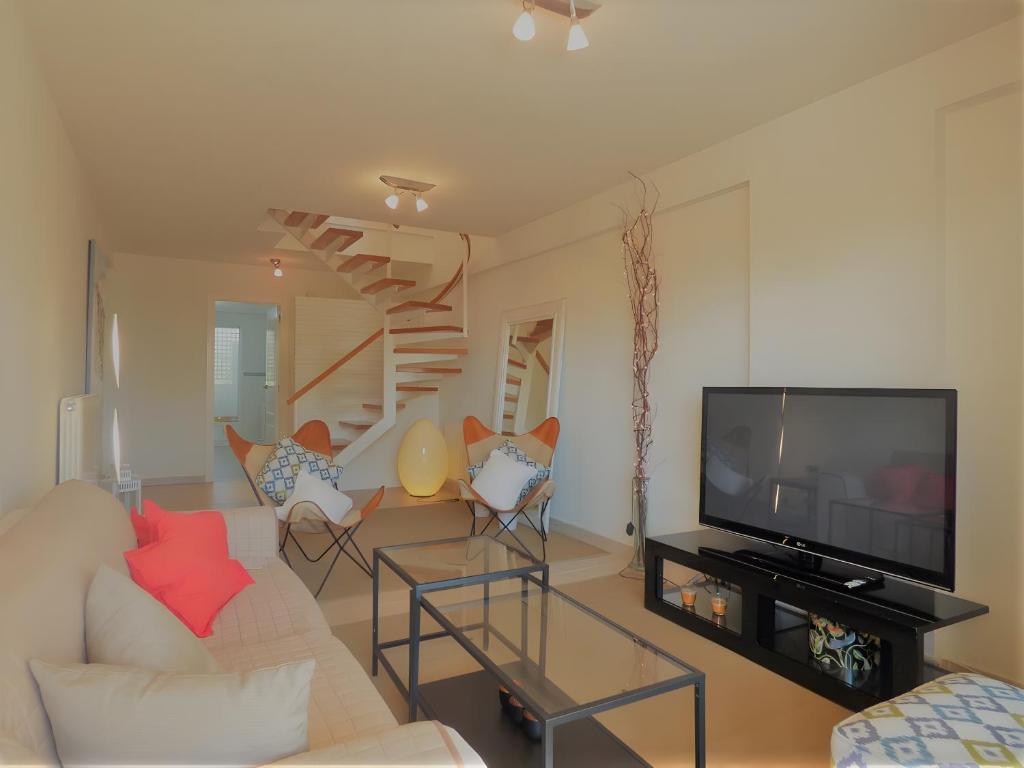 a living room with a couch and a television at Ático en Jávea - Solo Familias 1813 in Platja de l'Arenal