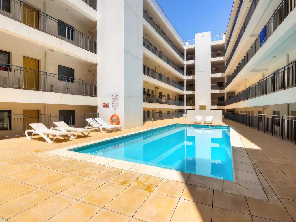 a swimming pool in the courtyard of a building at Ria Formosa Pool Heaven in Olhão
