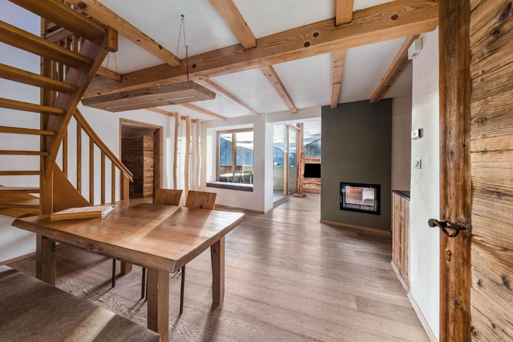 a dining room with a wooden table and stairs at Naturoase Stegerhof Apt Ringelblume in Trodena