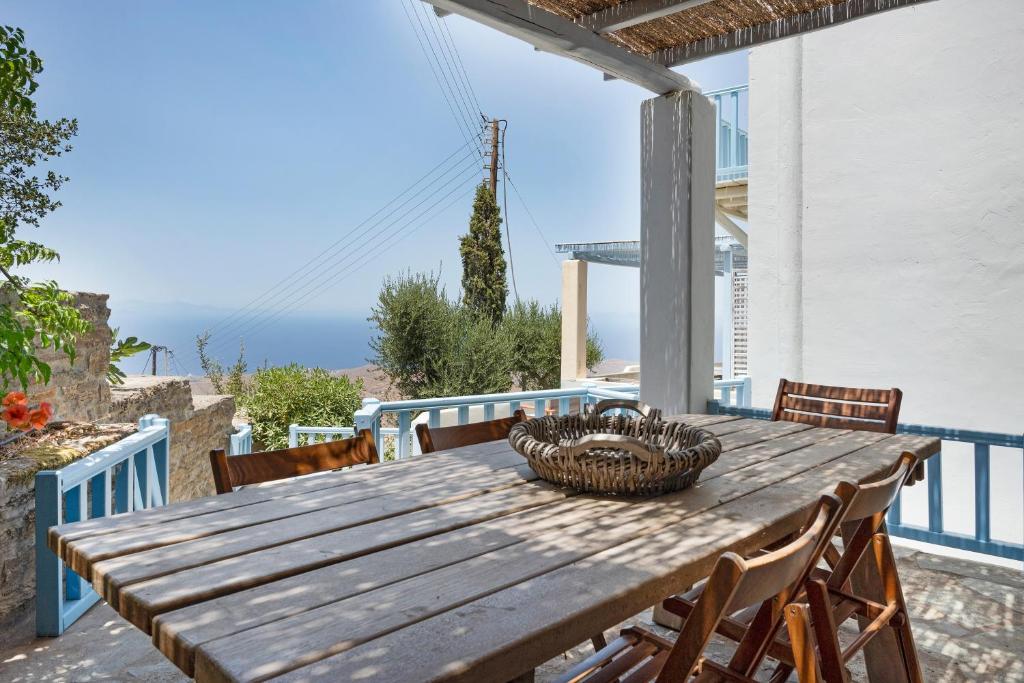 a wooden table with chairs and a basket on a patio at Efrossyni House in Ioulis