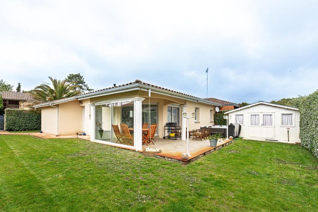 a house with a deck and a backyard at Villa Melchivany - Nature et Océan in Messanges
