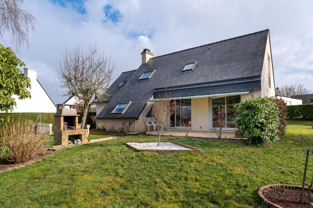 a house with a gambrel roof and a yard at Maison entre terre et mer in Pluvigner