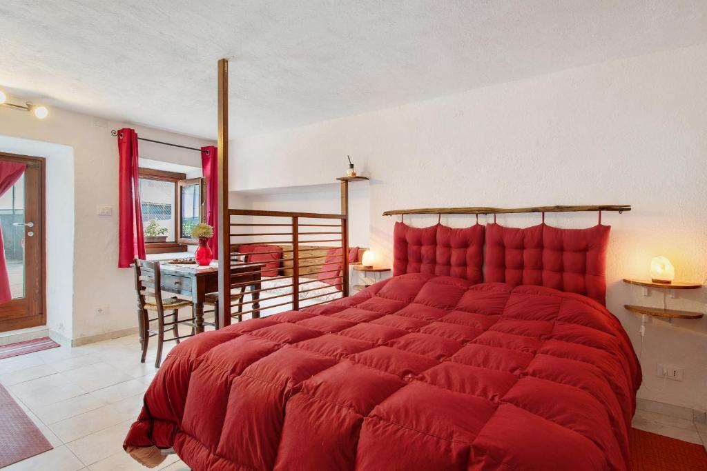 a large red bed in a room with a table at Nel Cuore della Via Francigena in Aosta