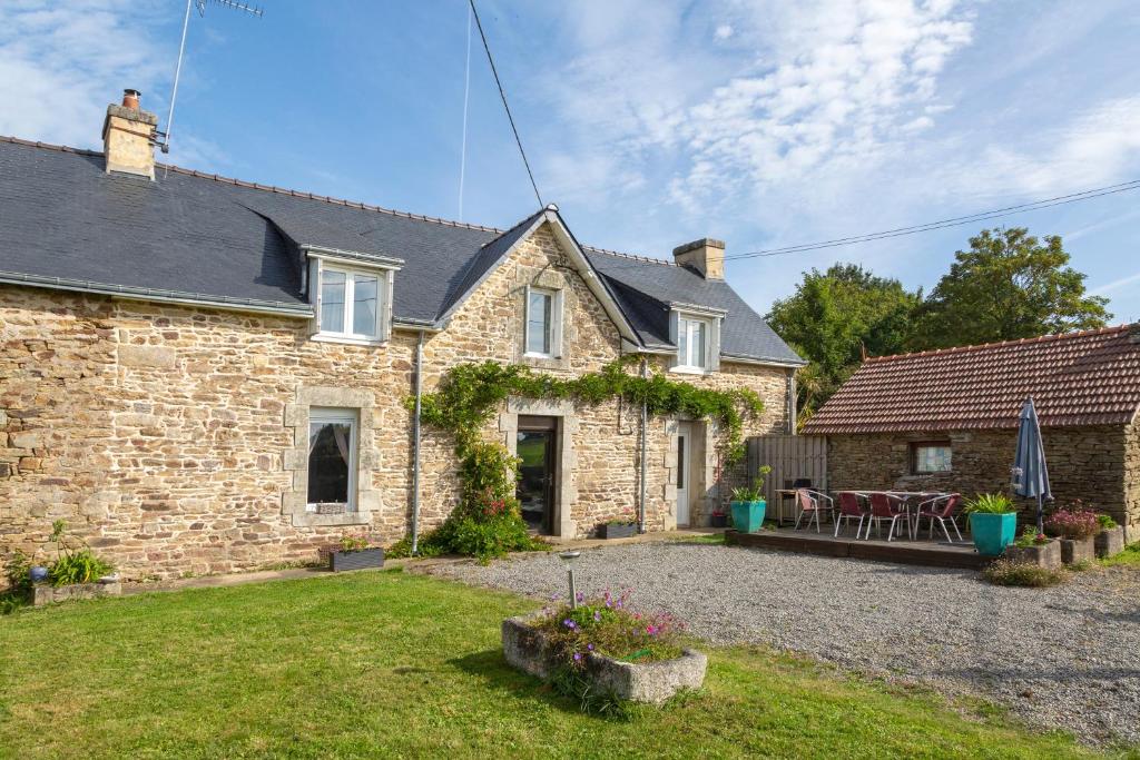 a brick house with a patio in the yard at Longère 5min de Pont-Aven in Riec-sur-Bélon