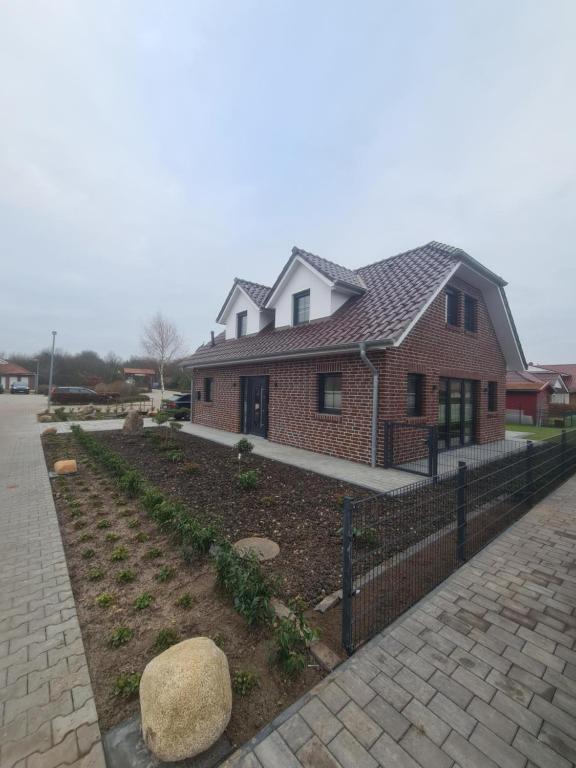 a house with a fence in front of a yard at Emily in Geeste