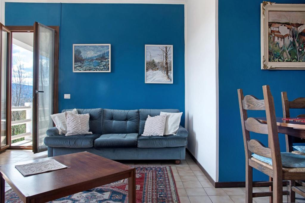 a blue living room with a couch and a table at Home Pier in Laveno-Mombello