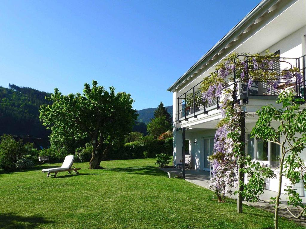 a white house with a bench in the yard at Ferienwohnung Peterberg 22, 45qm in Kirchzarten