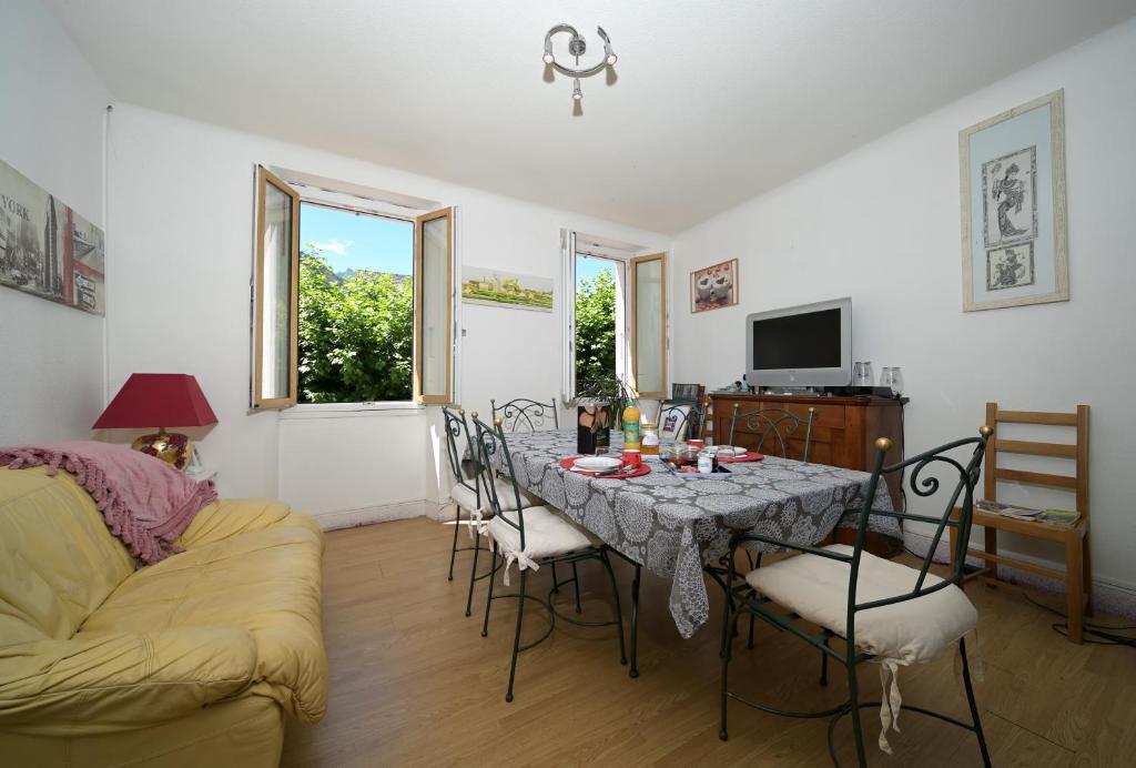a living room with a table with chairs and a couch at Chambre Verte in Auzat