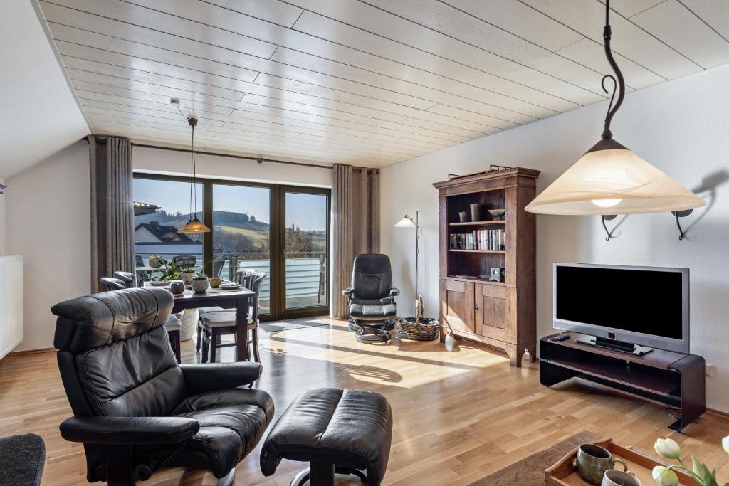 a living room with a television and a table and chairs at Vista-Homert in Eslohe
