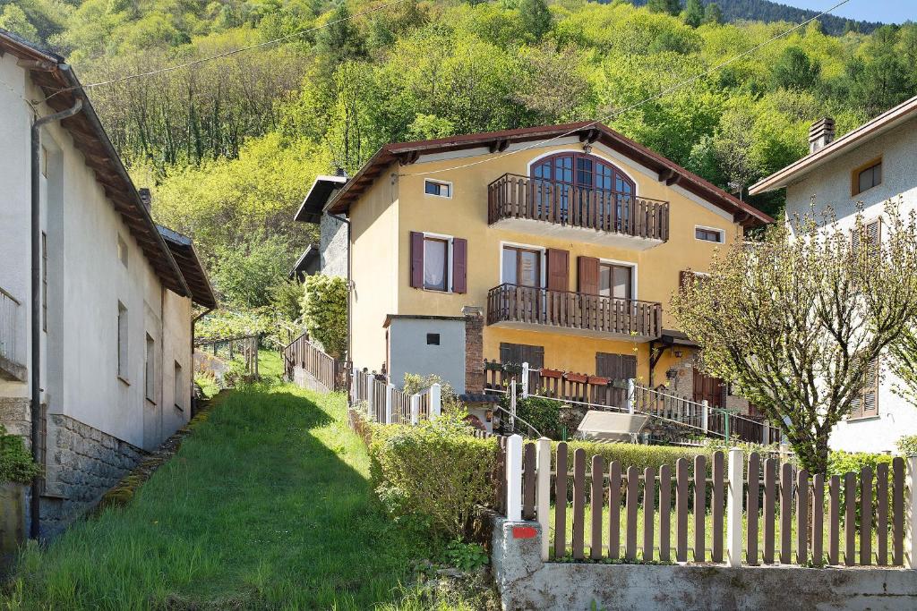 a yellow house with a fence in front of it at In Valtellina da Valter e Lella in Colorina