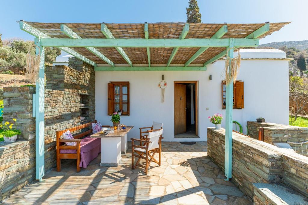 a patio with a stone wall and a pergola at Archontiko Keli in Katákoilos