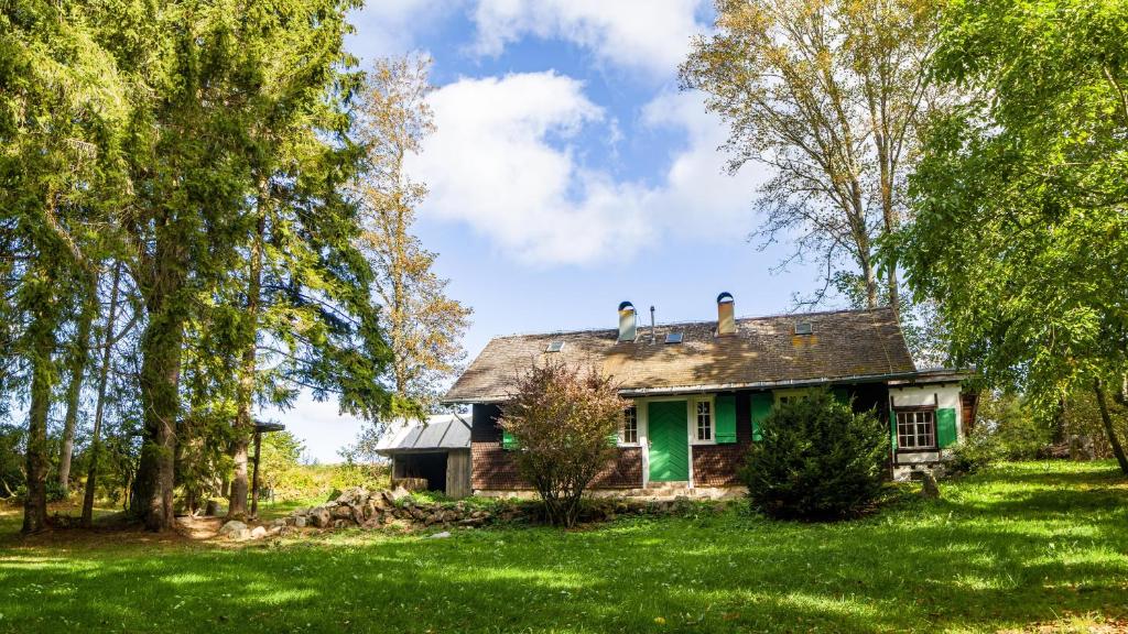 an old house in a field with trees at Das Schneiderhaus in Höchenschwand
