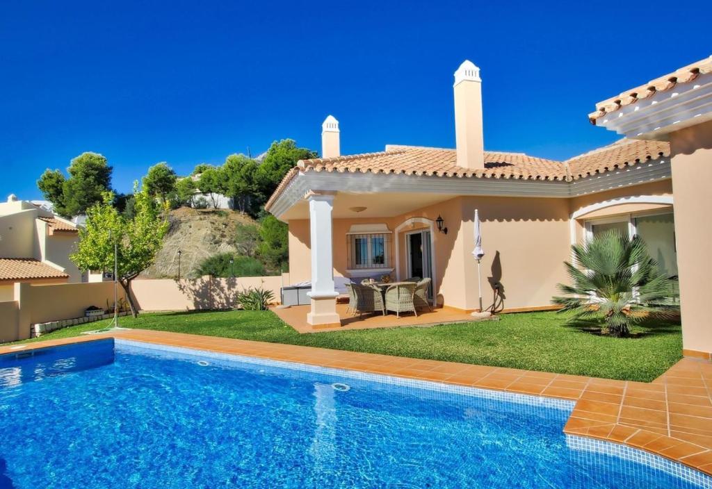 a villa with a swimming pool in front of a house at Luxurius Villa with private pool in Mijas