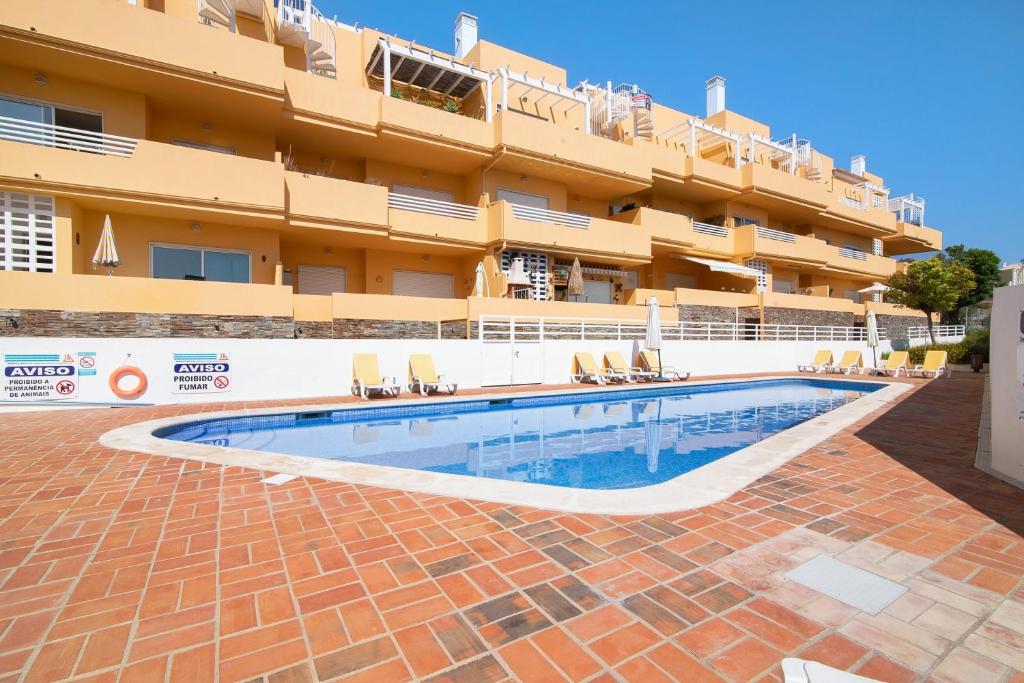 a swimming pool in front of a hotel at Royal Cabanas Golf 87 in Cabanas de Tavira