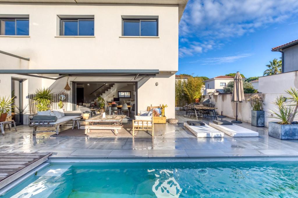 a house with a swimming pool in front of a house at Sublime Maison Moderne avec piscine in Mauguio