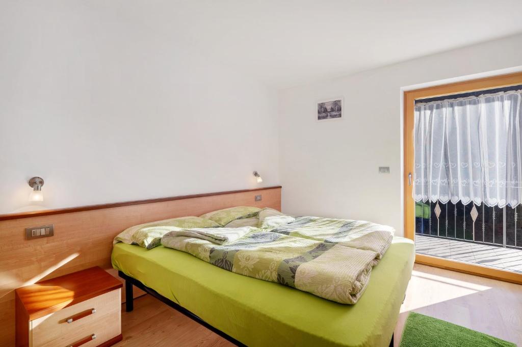 a bedroom with a bed and a large window at Innerjerberhof Neiderseit in Lauregno