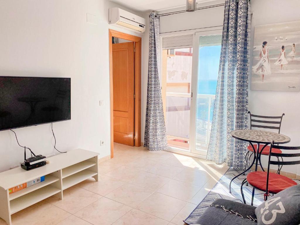 a living room with a tv and a table at Constance in L'Ampolla
