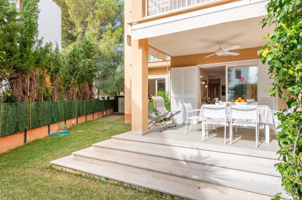 a house with a wooden deck with a table and chairs at Apartamento Olot in Pollença