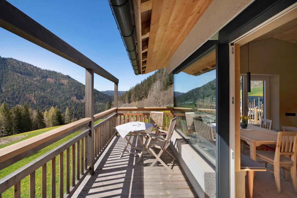 a balcony of a house with a table and chairs at Pitschlhof Apt Zirbe in Aldino