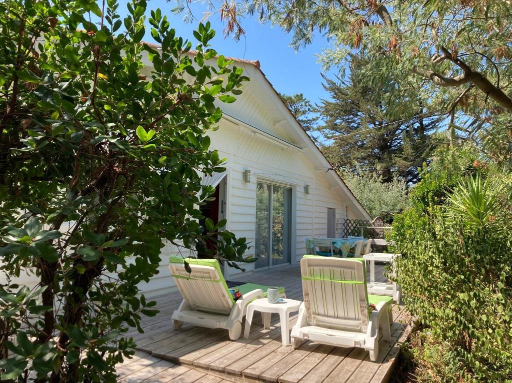 a patio with two chairs and a table at Villa Cap Ferret - Réf 230 in Lège-Cap-Ferret